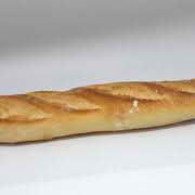 A baguette resting on a white surface, showcasing its long shape and crusty exterior