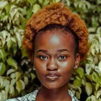 A woman named Olivia Ava with a stylish afro hairstyle, radiating confidence and charm
