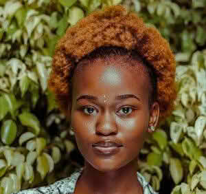 A woman named Olivia Ava with a stylish afro hairstyle, radiating confidence and charm